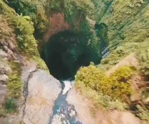incredible drone shot gliding down a waterfall
